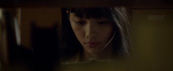 Movie still from “Revenge of the Green Dragons” (2014), directed by Andrew Loo – A young woman is looking down at her phone; Close Up shot, Low angle
