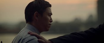 Movie still from “Revenge of the Green Dragons” (2014), directed by Andrew Loo – A man with his arm around another mans shoulder; Close Up shot, Over the shoulder angle