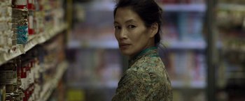 Movie still from “Revenge of the Green Dragons” (2014), directed by Andrew Loo – A woman in a green and brown floral shirt; Close Up shot, Over the shoulder angle