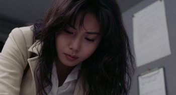 Movie still from “Ringu” (1998), directed by Hideo Nakata – A woman with long black hair is looking down at her face; Close Up shot, Low angle