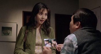 Movie still from “Ringu” (1998), directed by Hideo Nakata – A woman is holding a picture of a young man; Close Up shot, Over the shoulder angle