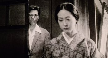 Movie still from “Ringu” (1998), directed by Hideo Nakata – A man and a woman standing next to each other; Close Up shot, Low angle