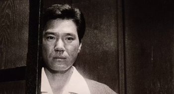 Movie still from “Ringu” (1998), directed by Hideo Nakata – An old photo of an asian man with a mustache; Extreme Close Up shot, Low angle