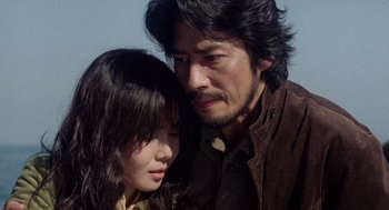 Movie still from “Ringu” (1998), directed by Hideo Nakata – A man and a woman standing next to each other; Close Up shot, Low angle