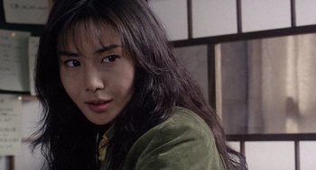 Movie still from “Ringu” (1998), directed by Hideo Nakata – A woman with long black hair wearing a green jacket; Close Up shot, Low angle
