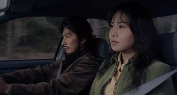 Movie still from “Ringu” (1998), directed by Hideo Nakata – A man and a woman sitting in the back of a car; Close Up shot, High angle