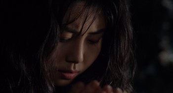 Movie still from “Ringu” (1998), directed by Hideo Nakata – A person with their eyes closed praying; Close Up shot, High angle