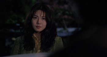 Movie still from “Ringu” (1998), directed by Hideo Nakata – A woman with long dark hair sitting in front of a tree; Close Up shot, Over the shoulder angle