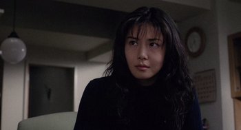 Movie still from “Ringu” (1998), directed by Hideo Nakata – A woman with long black hair is looking into the distance; Close Up shot, Low angle