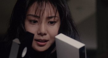 Movie still from “Ringu” (1998), directed by Hideo Nakata – A person looking at a cell phone; Close Up shot, High angle