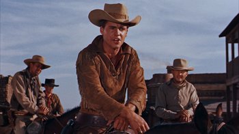 Movie still from “Rio Bravo” (1959), directed by Howard Hawks – A man in a cowboy hat riding a horse; Medium shot, Low angle