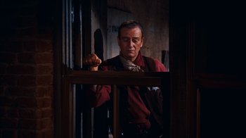 Movie still from “Rio Bravo” (1959), directed by Howard Hawks – A man in a red shirt holding a wooden stick; Medium shot, Low angle