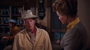 Movie still from “Rio Bravo” (1959), directed by Howard Hawks – An older man wearing a cowboy hat talking to an older woman; Medium shot, Over the shoulder angle
