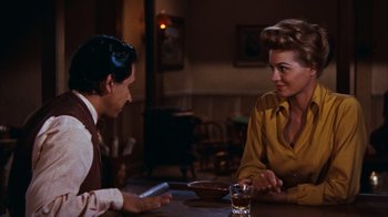 Movie still from “Rio Bravo” (1959), directed by Howard Hawks – A man and a woman sitting at a dinner table; Medium shot, Over the shoulder angle