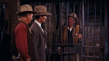 Movie still from “Rio Bravo” (1959), directed by Howard Hawks – A group of men standing next to each other in front of a fence; Medium shot, High angle