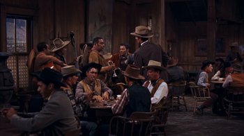 Movie still from “Rio Bravo” (1959), directed by Howard Hawks – A group of men sitting around a table playing cards; Wide shot, High angle