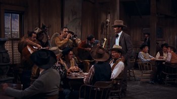 Movie still from “Rio Bravo” (1959), directed by Howard Hawks – A group of men sitting around a table playing cards; Wide shot, High angle