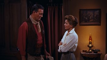 Movie still from “Rio Bravo” (1959), directed by Howard Hawks – A man and a woman standing next to each other in a room; Medium shot, Low angle
