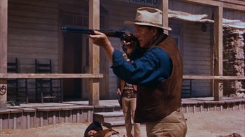 Movie still from “Rio Bravo” (1959), directed by Howard Hawks – A man with a hat and a gun in his hand; Medium shot, Low angle