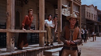 Movie still from “Rio Bravo” (1959), directed by Howard Hawks – A group of people standing on a porch; Wide shot, Low angle