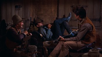 Movie still from “Rio Bravo” (1959), directed by Howard Hawks – A group of people sitting in a room; Wide shot, Over the shoulder angle
