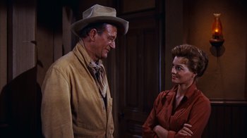 Movie still from “Rio Bravo” (1959), directed by Howard Hawks – A man and a woman standing next to each other; Medium shot, Over the shoulder angle