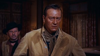 Movie still from “Rio Bravo” (1959), directed by Howard Hawks – A person wearing a suit and tie; Medium shot, Low angle