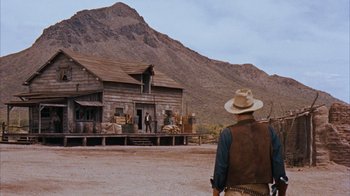 Movie still from “Rio Bravo” (1959), directed by Howard Hawks – A man standing in front of a wooden house; Extreme Wide shot, Low angle