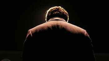 Movie still from “RoboCop” (2014), directed by José Padilha – A man in a brown jacket standing in the dark; Extreme Close Up shot, Low angle