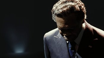 Movie still from “RoboCop” (2014), directed by José Padilha – A person wearing a suit and tie; Close Up shot, High angle