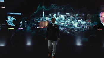 Movie still from “RoboCop” (2014), directed by José Padilha – A man walking in front of a projection of a city; Wide shot, Low angle