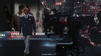 Movie still from “RoboCop” (2014), directed by José Padilha – A man standing in front of a video camera; Wide shot, Over the shoulder angle