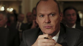 Movie still from “RoboCop” (2014), directed by José Padilha – A man in a suit and tie holding his hand to his chin; Close Up shot, Low angle