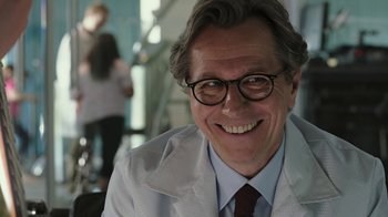 Movie still from “RoboCop” (2014), directed by José Padilha – An older man wearing glasses and a white coat; Close Up shot, Over the shoulder angle