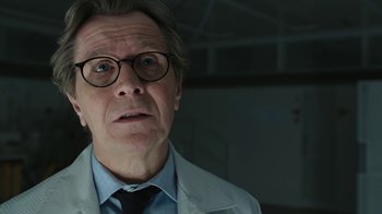 Movie still from “RoboCop” (2014), directed by José Padilha – An older man wearing a white lab coat and glasses; Close Up shot, Low angle