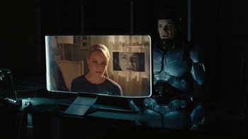 Movie still from “RoboCop” (2014), directed by José Padilha – A man and a woman in front of a television screen; Medium shot, Over the shoulder angle