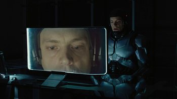 Movie still from “RoboCop” (2014), directed by José Padilha – A man is watching a video of a man's face on a computer screen; Close Up shot, Over the shoulder angle