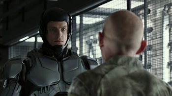 Movie still from “RoboCop” (2014), directed by José Padilha – A man wearing a helmet is looking into a mirror; Close Up shot, Over the shoulder angle