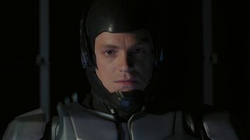 Movie still from “RoboCop” (2014), directed by José Padilha – A man wearing a helmet is looking into the camera; Close Up shot, Low angle