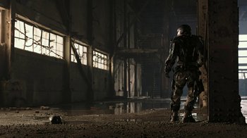 Movie still from “RoboCop” (2014), directed by José Padilha – A man standing in an industrial setting with a gun; Wide shot, Low angle