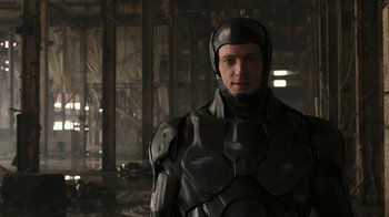 Movie still from “RoboCop” (2014), directed by José Padilha – A man wearing a black suit and helmet; Close Up shot, Low angle