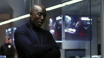 Movie still from “RoboCop” (2014), directed by José Padilha – A man with his arms crossed standing in front of a window; Close Up shot, Low angle