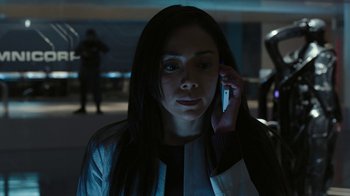 Movie still from “RoboCop” (2014), directed by José Padilha – A woman is talking on a cell phone in the dark; Medium shot, Low angle