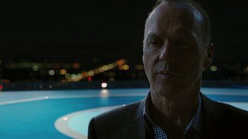 Movie still from “RoboCop” (2014), directed by José Padilha – An older man in a suit standing in front of a pool at night; Close Up shot, Over the shoulder angle