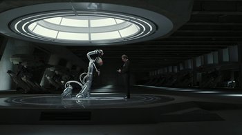 Movie still from “RoboCop” (2014), directed by José Padilha – A man standing next to a robot in a room; Wide shot, High angle