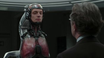 Movie still from “RoboCop” (2014), directed by José Padilha – A man in a suit and helmet is talking to another man; Close Up shot, Over the shoulder angle