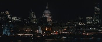 Movie still from “RocknRolla” (2008), directed by Guy Ritchie – A view of a city at night from across the river; Extreme Wide shot, High angle