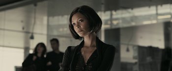 Movie still from “RocknRolla” (2008), directed by Guy Ritchie – A woman in a black shirt is looking to her left; Close Up shot, Over the shoulder angle
