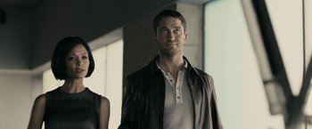 Movie still from “RocknRolla” (2008), directed by Guy Ritchie – A man and a woman standing next to each other; Medium shot, Low angle