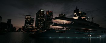 Movie still from “RocknRolla” (2008), directed by Guy Ritchie – A boat in a body of water near a large city; Extreme Wide shot, Low angle
